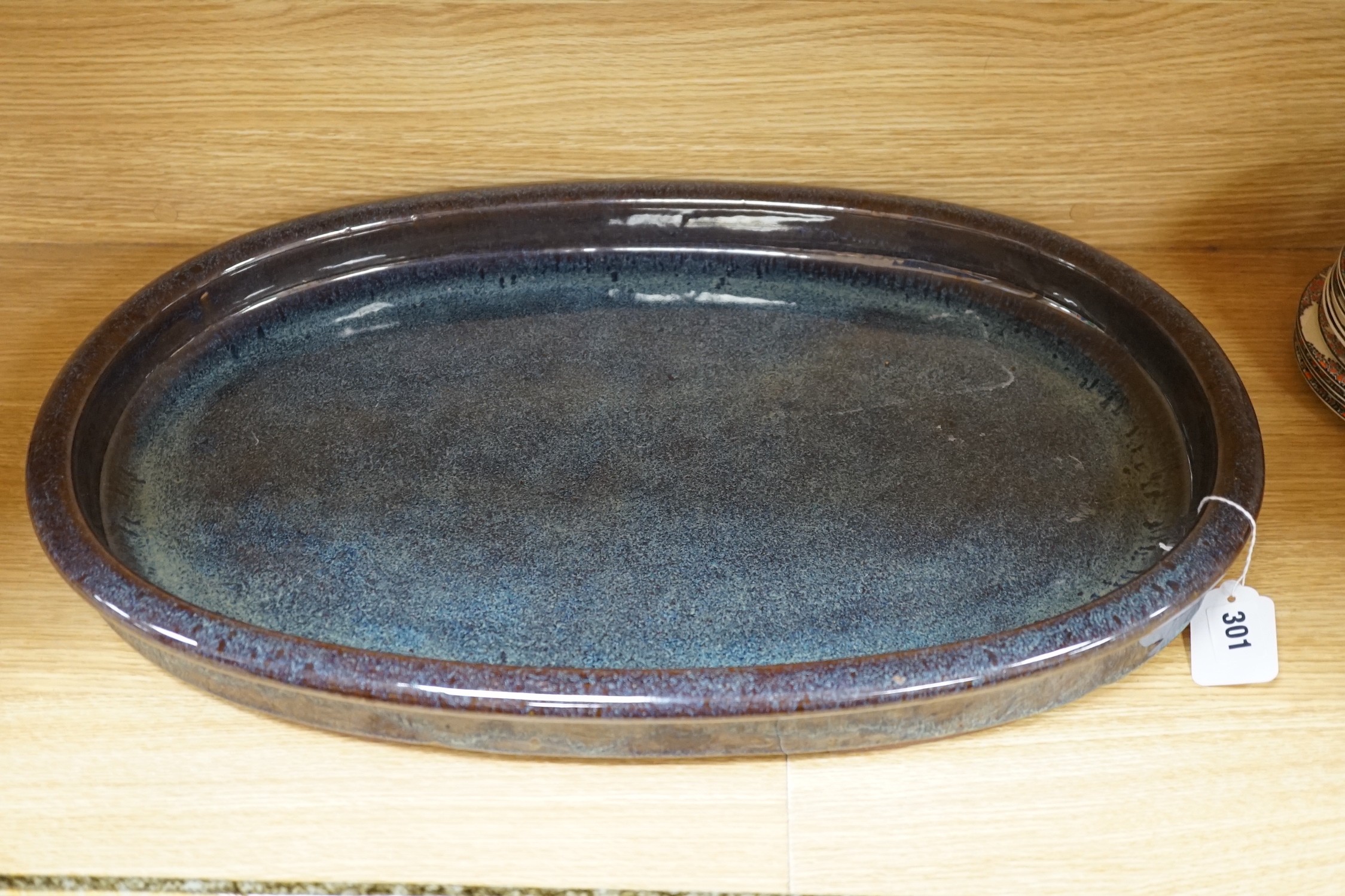 A large Japanese studio pottery oval dish and a larger studio pottery rectangular dish, largest 60cms wide x 24.5cms deep